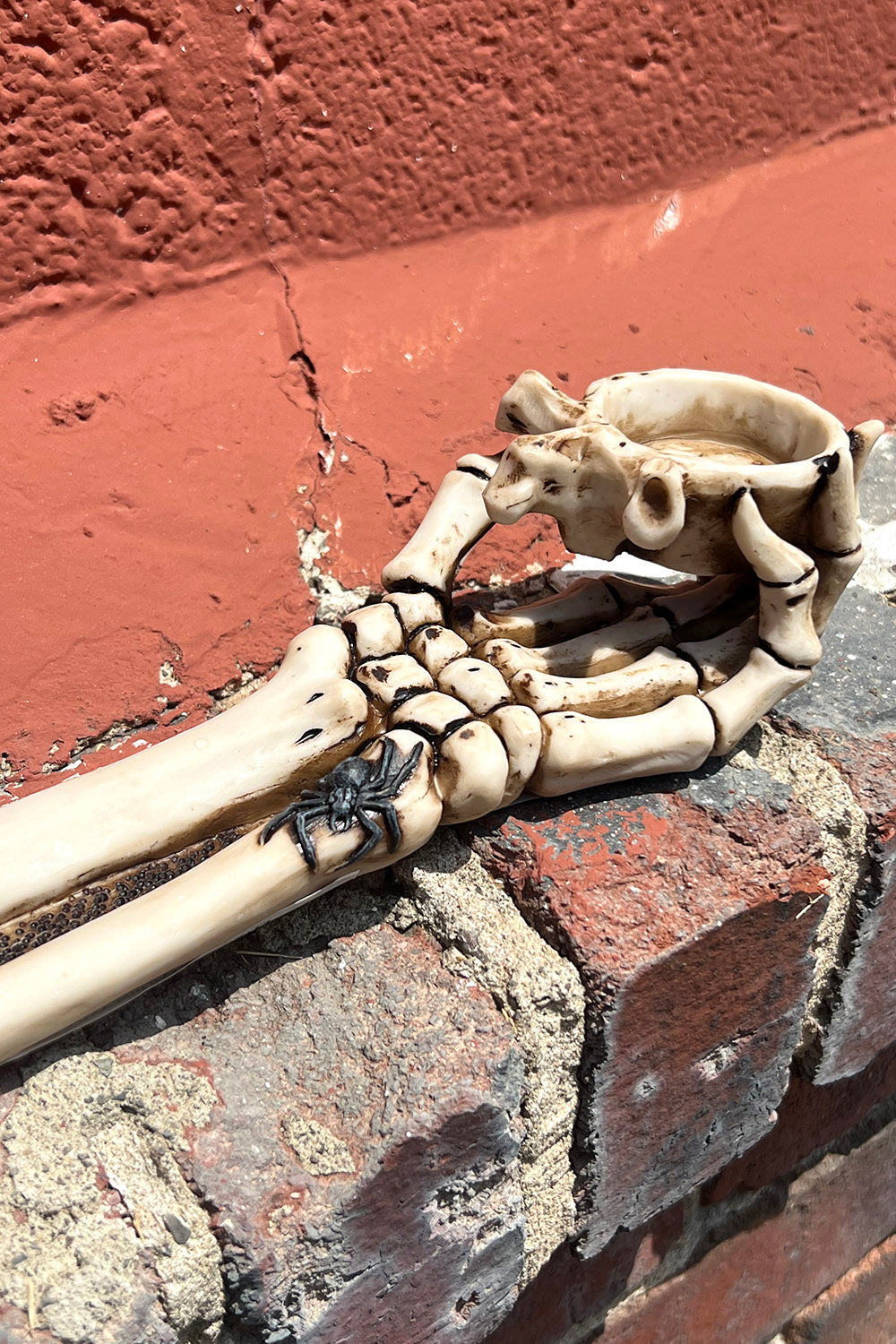 Quemador de velas con forma de mano de esqueleto