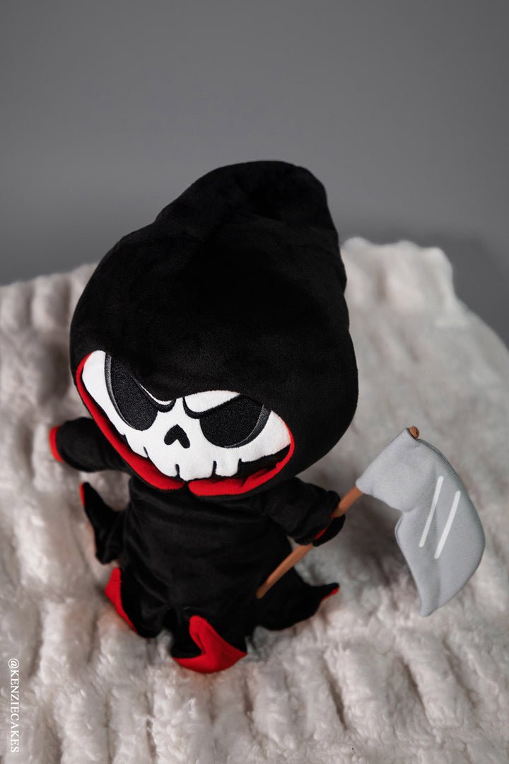 grim reaper plush toy holding scythe