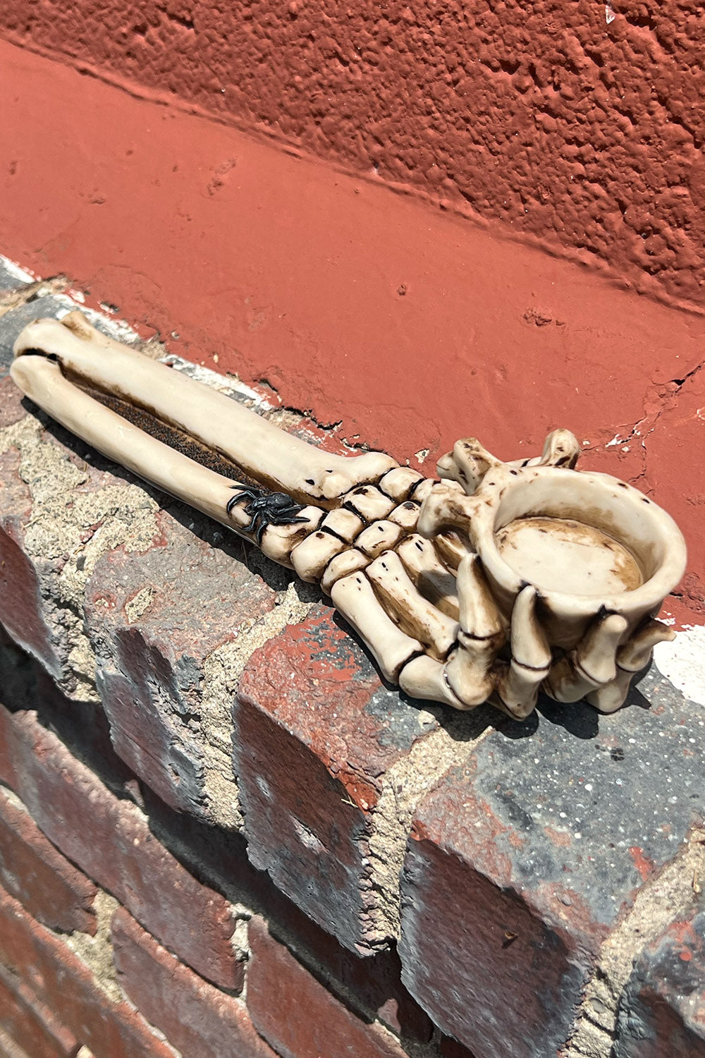 Quemador de velas con forma de mano de esqueleto