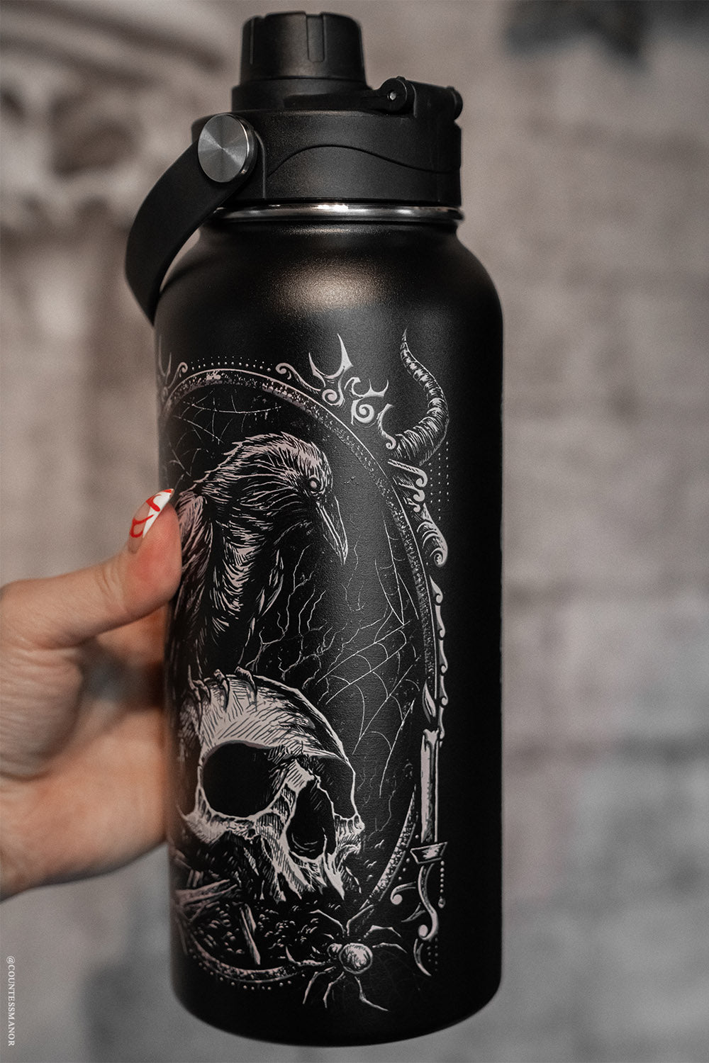 stainless steel raven sitting on skull water bottle