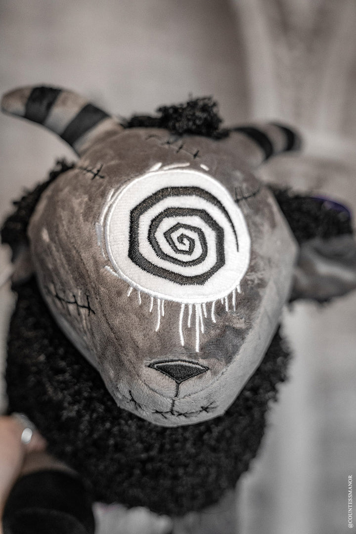 goth sheep plush toy with spiral eye and striped horns