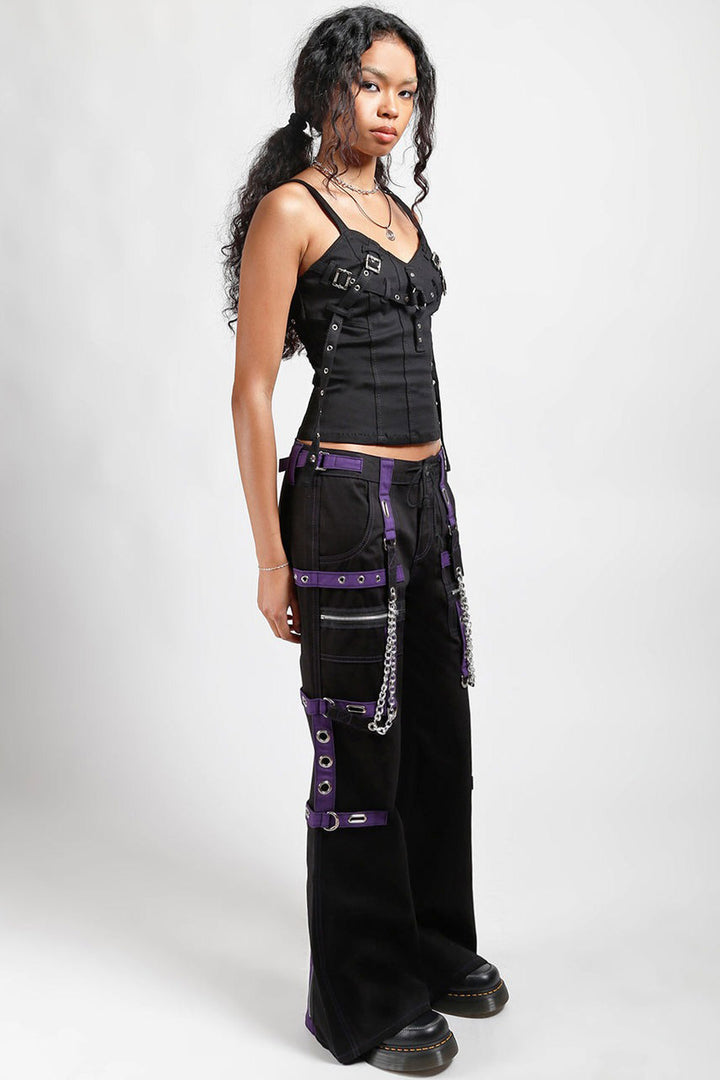 gothic girl wearing a black and purple cargo pants with chain details on a white background