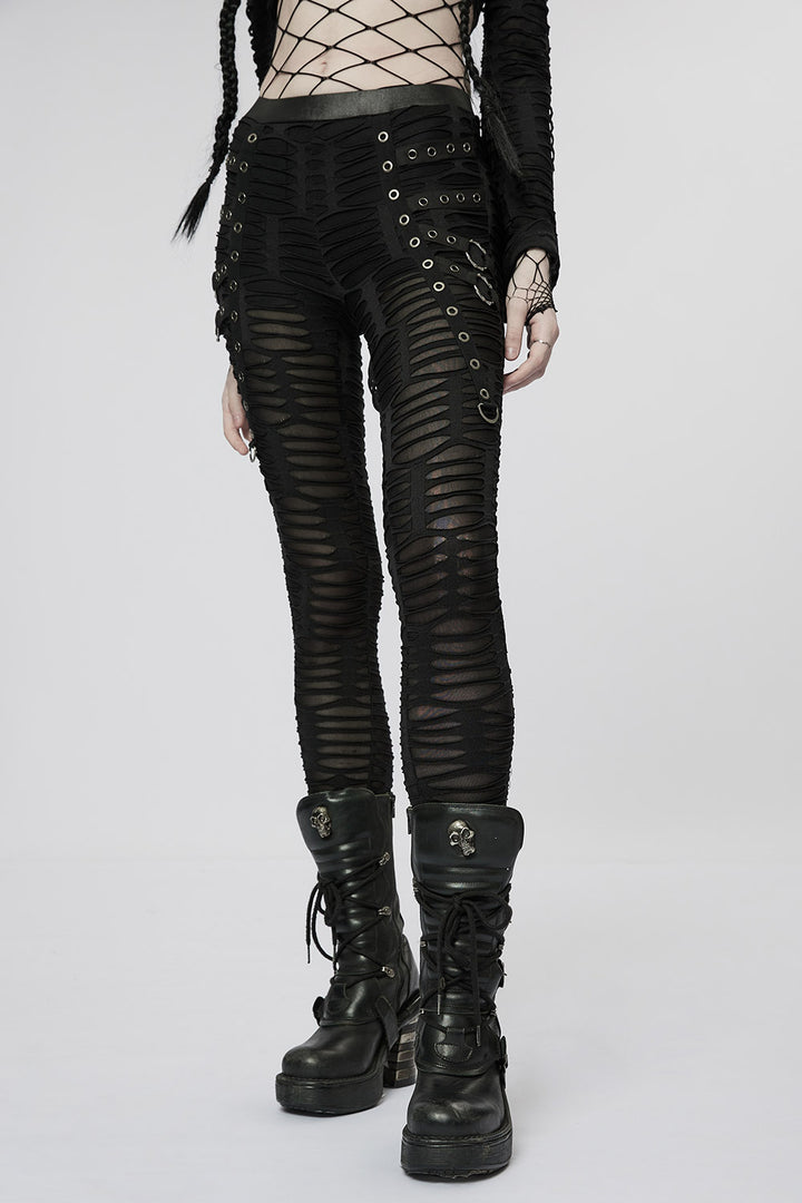 Person wearing black distressed leggings pants and boots on a white background