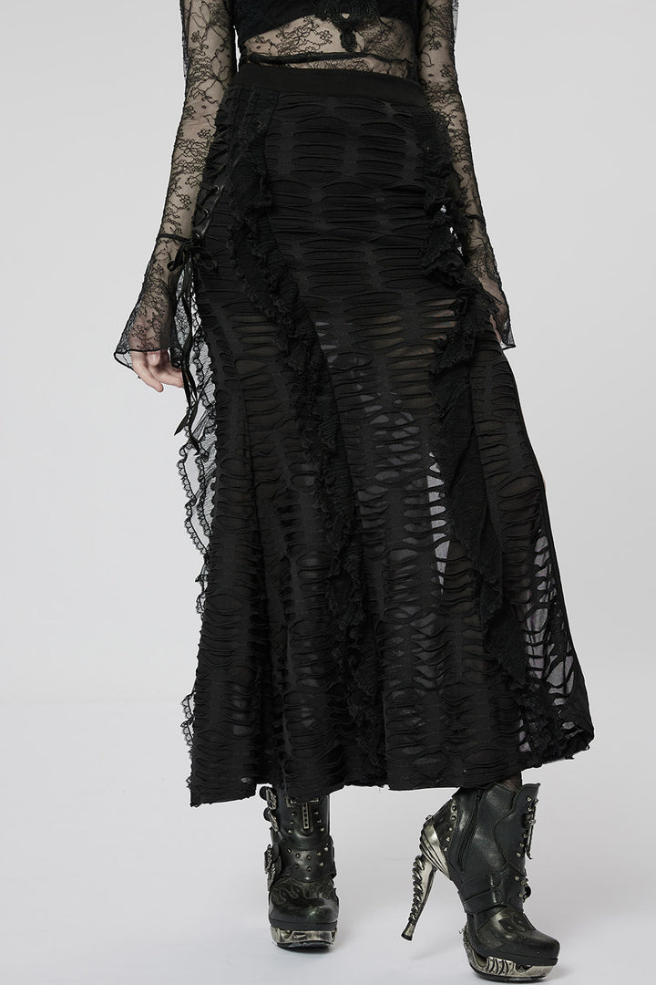 Person wearing a black lace outfit with a long skirt on a white background
