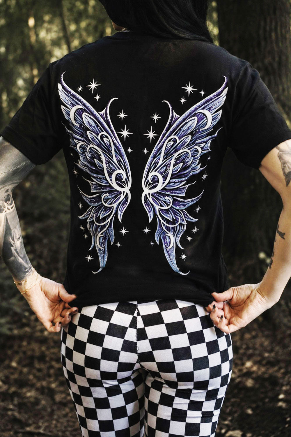 Person wearing a black t-shirt with fairy wings design outdoors