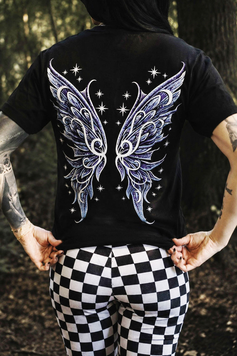 Person wearing a black t-shirt with fairy wings design outdoors
