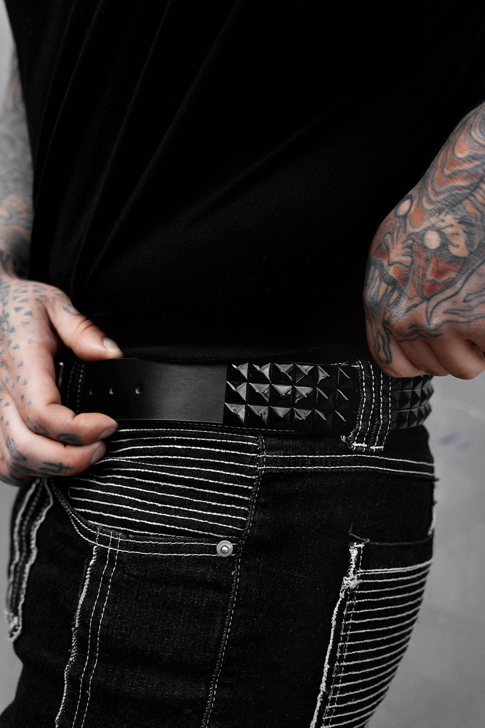 authentic genuine real leather black pyramid studded belt worn by a man with tattoos 