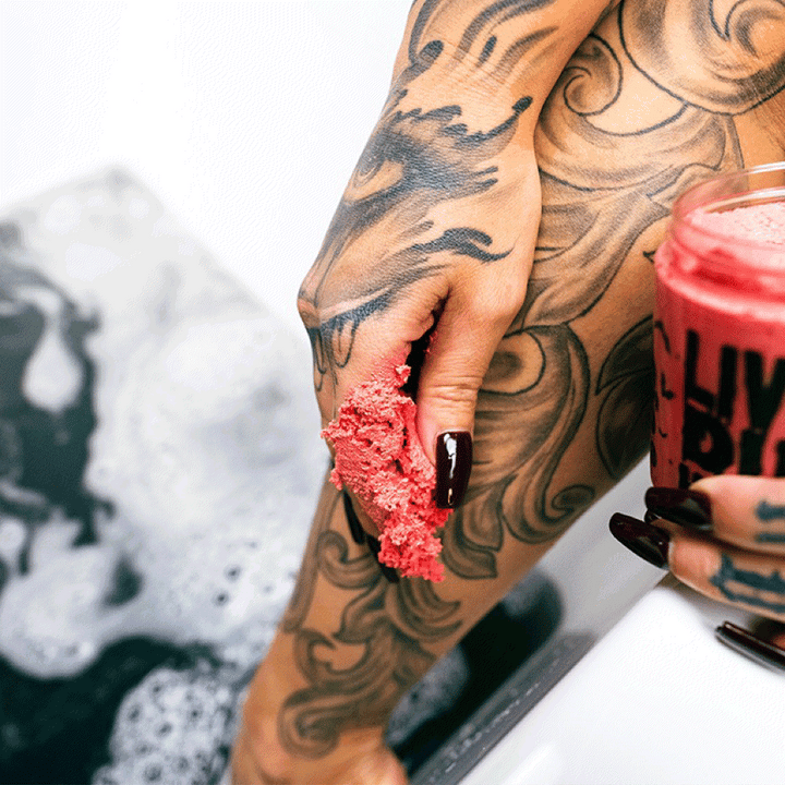 video of a gothic woman with tattoos using gothic sugar scrub in a gothic bathtub 