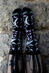 dark cottagecore knitted socks featuring moons, moths, and flowers