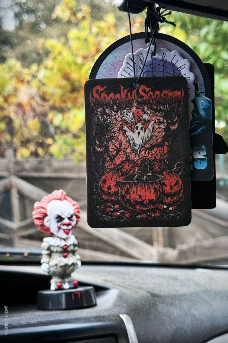 Decorative air freshener with a clown design on a car dashboard.