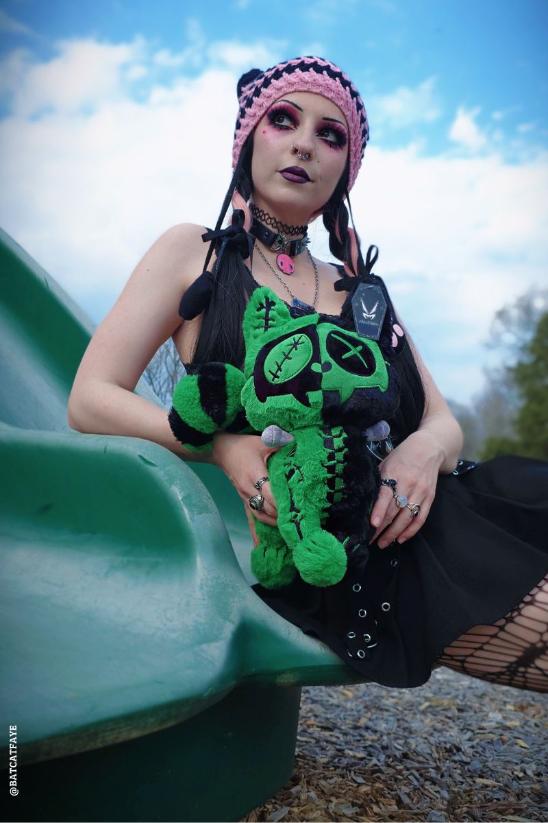 emo woman holding a frankenstein stuffed animal cat