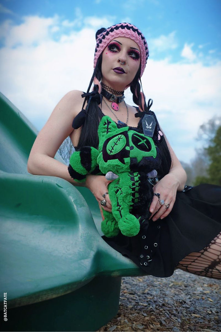 emo woman holding a frankenstein stuffed animal cat