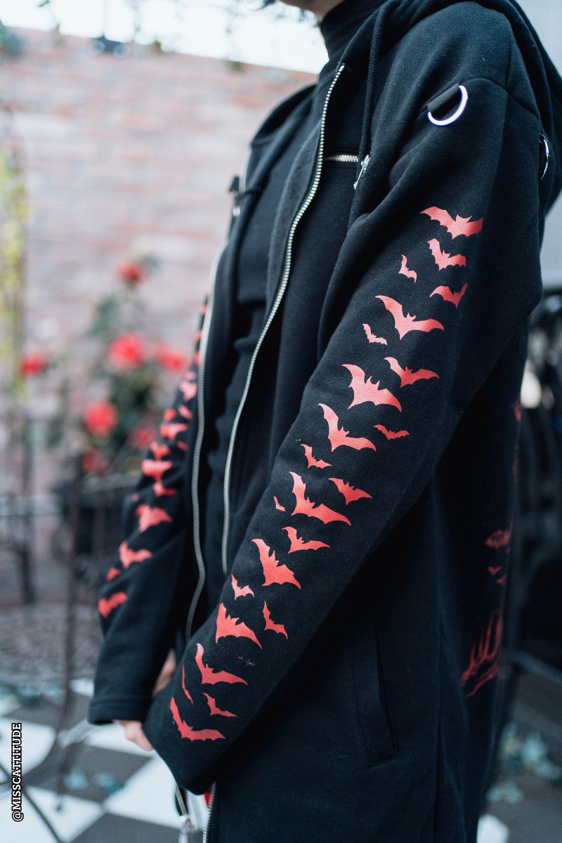 scene woman wearing a gothic hoodie with bat sleeves