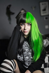 emo woman with green and black split hair wearing an alice down the rabbit hole emo hoodie