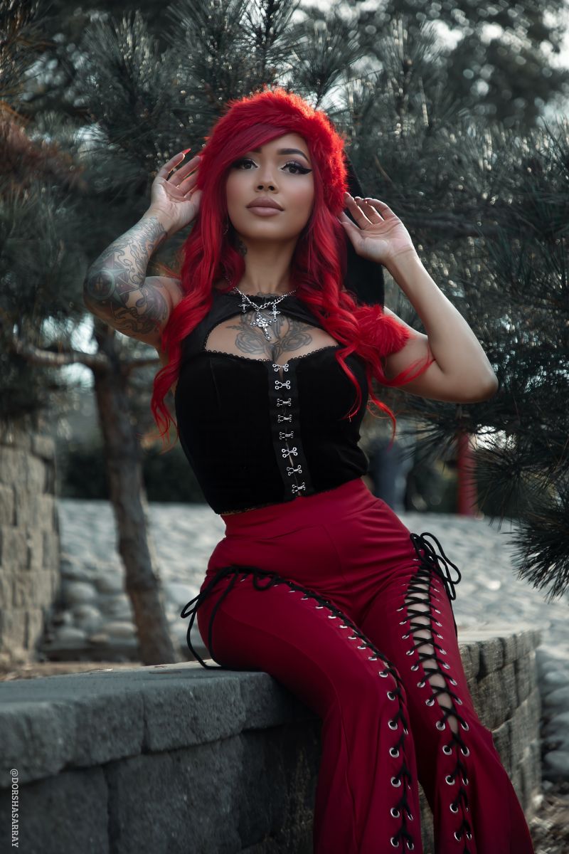 goth girl wearing a red and black santa clause hat