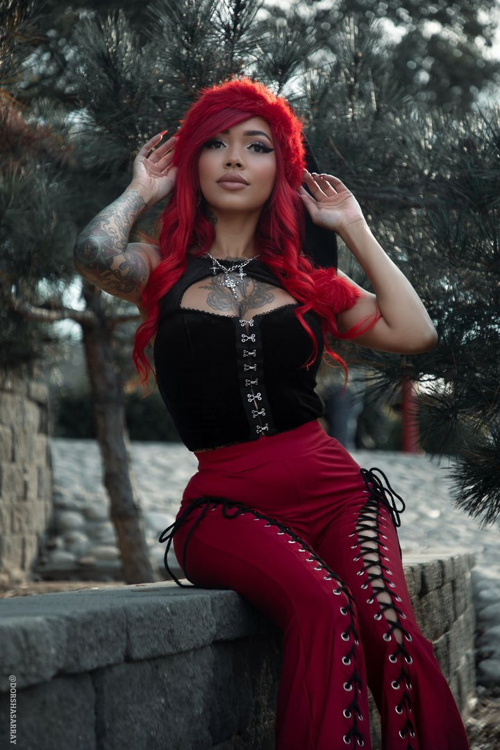 goth girl wearing a red and black santa clause hat