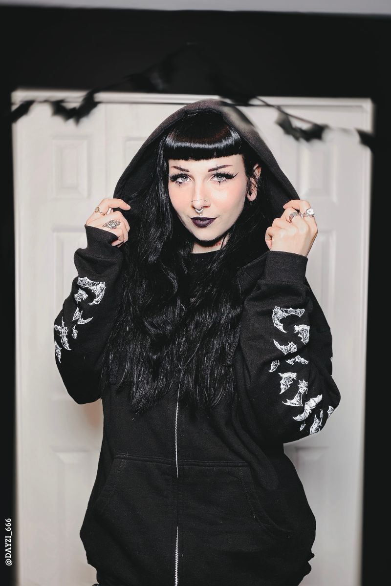 gothic woman wearing a gothic bat hoodie with bat sleeves