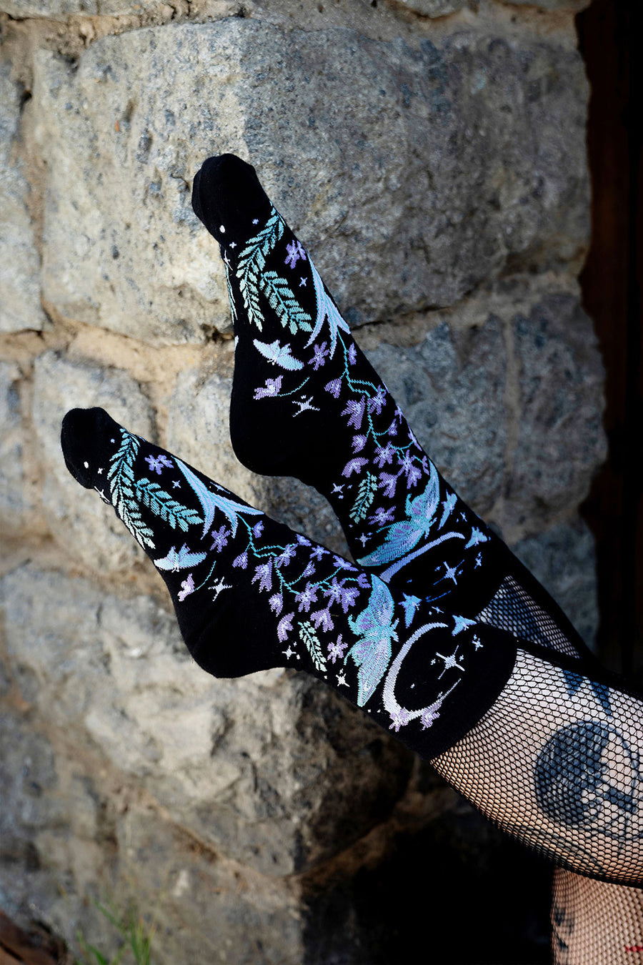 dark fantasy knitted socks featuring moons, moths, and flowers