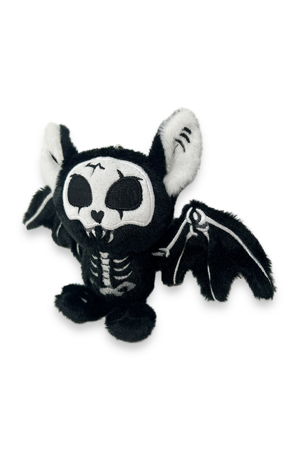 Black and white skeleton plush toy with bat wings on a white background