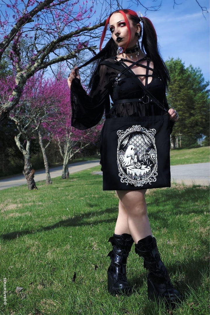 gothic girl wearing a zipper tote bag with a ghost design