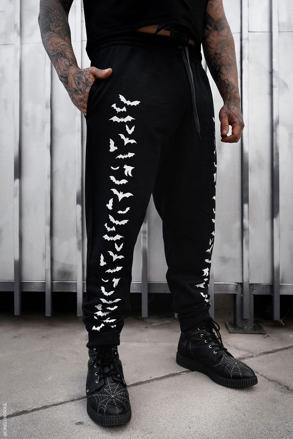 black jogger pants with bats printed on them