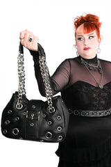 Gothic black grommet handbag styled with an alternative outfit, sheer black sleeves, and dark romantic punk fashion