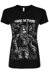 A black short-sleeve graphic t-shirt featuring a detailed white and gray illustration of a skeletal figure with wings, accompanied by the text 'HANG IN THERE' across the chest.