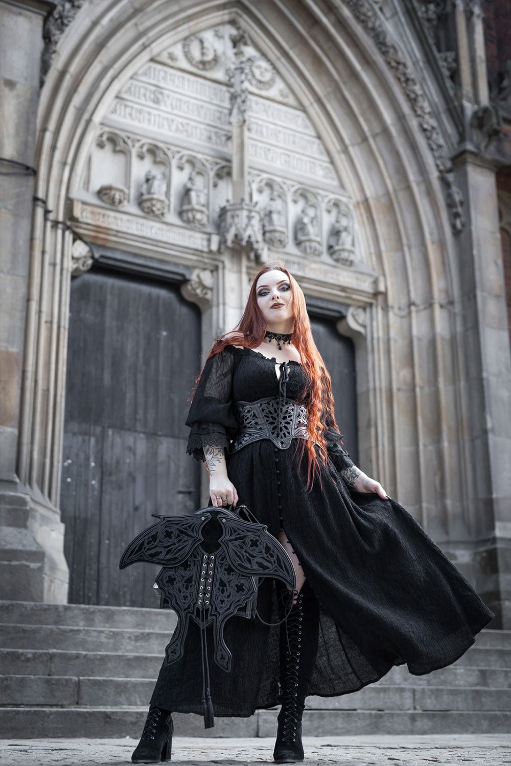Model holding occult black suede moth backpack