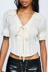 Womens blouse with tie front and ruffle sleeves on model
