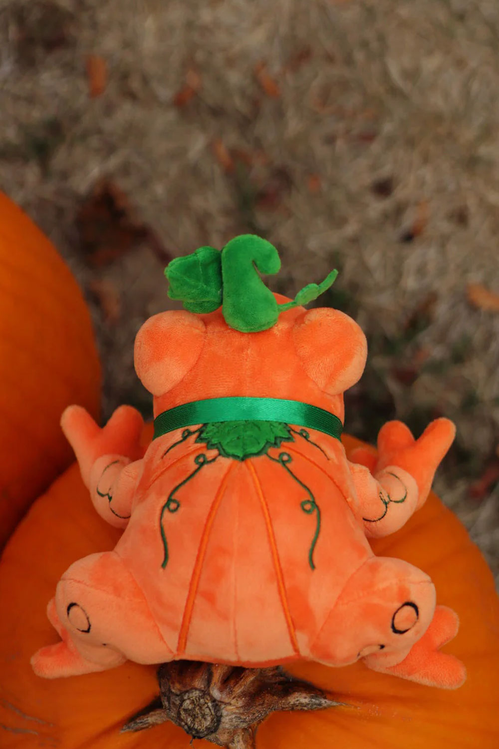 Halloween themed pumpkin inspired orange toad plush toy with green ribbon