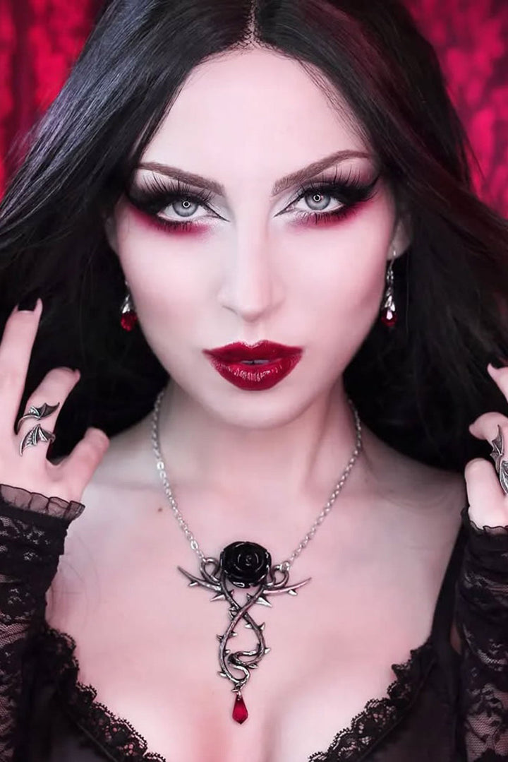 gothic woman wearing a black rose necklace with red crystal dropper
