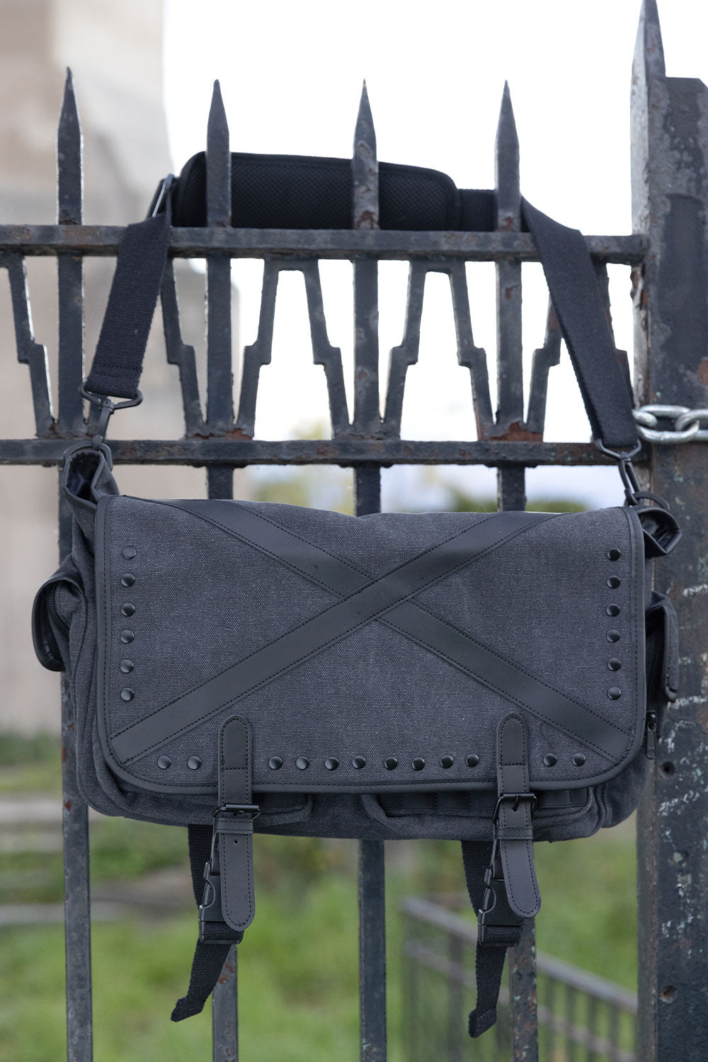 Gothic grey distressed messenger bag with black stud hardware buckle straps and multiple utility pouches for goth punk emo and grunge fashion