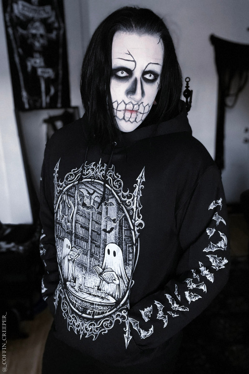 gothic man wearing corpse paint wearing a gothic ghost hoodie of ghosts reading books