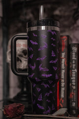 Black tumbler with purple bat pattern in a dark, possibly Halloween-themed setting.