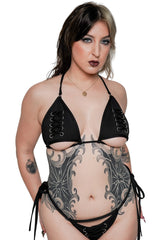 Woman wearing a black lace-up bikini set on a white background