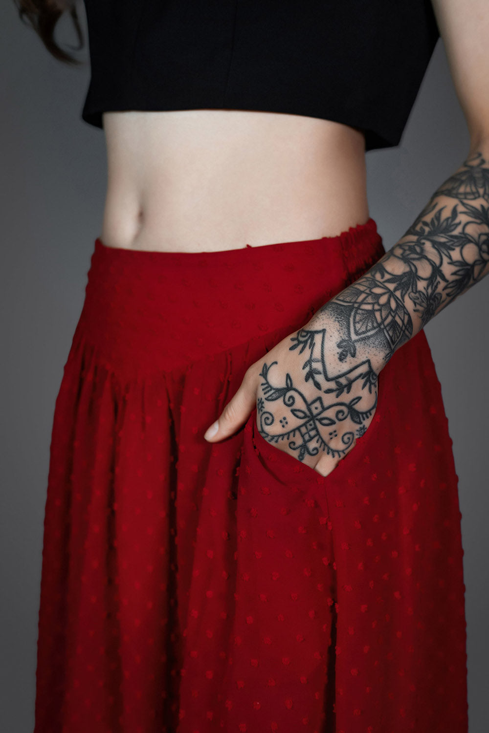 flowing red high-waisted skirt with v-shaped hem and pockets