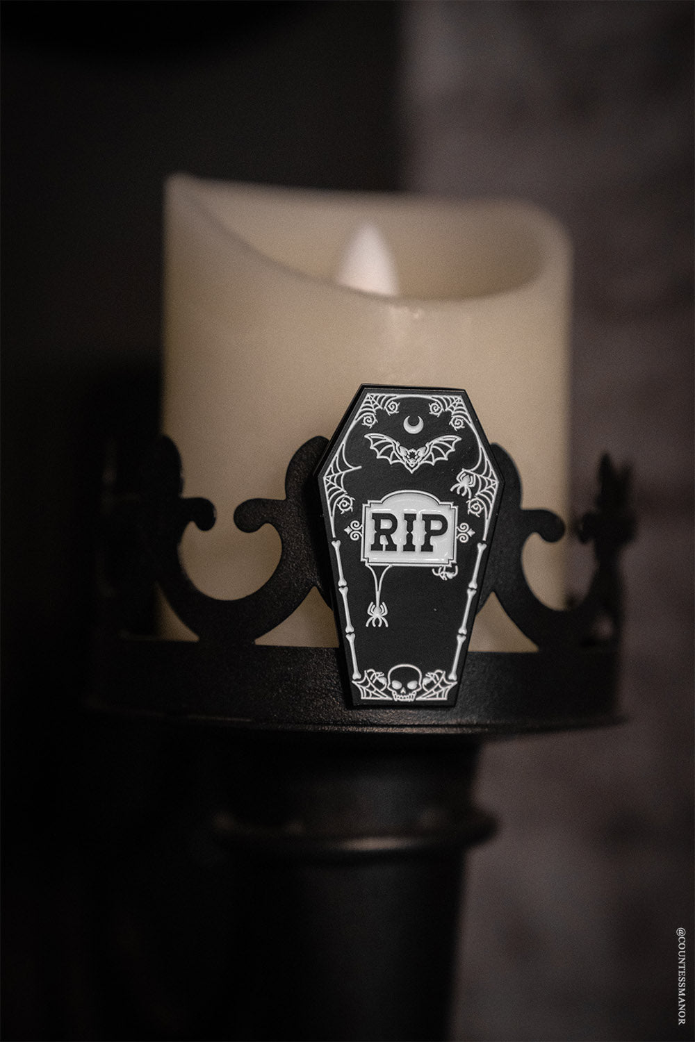 gothic enamel pin with RIP letting and spiderwebs, bats, and a skull 