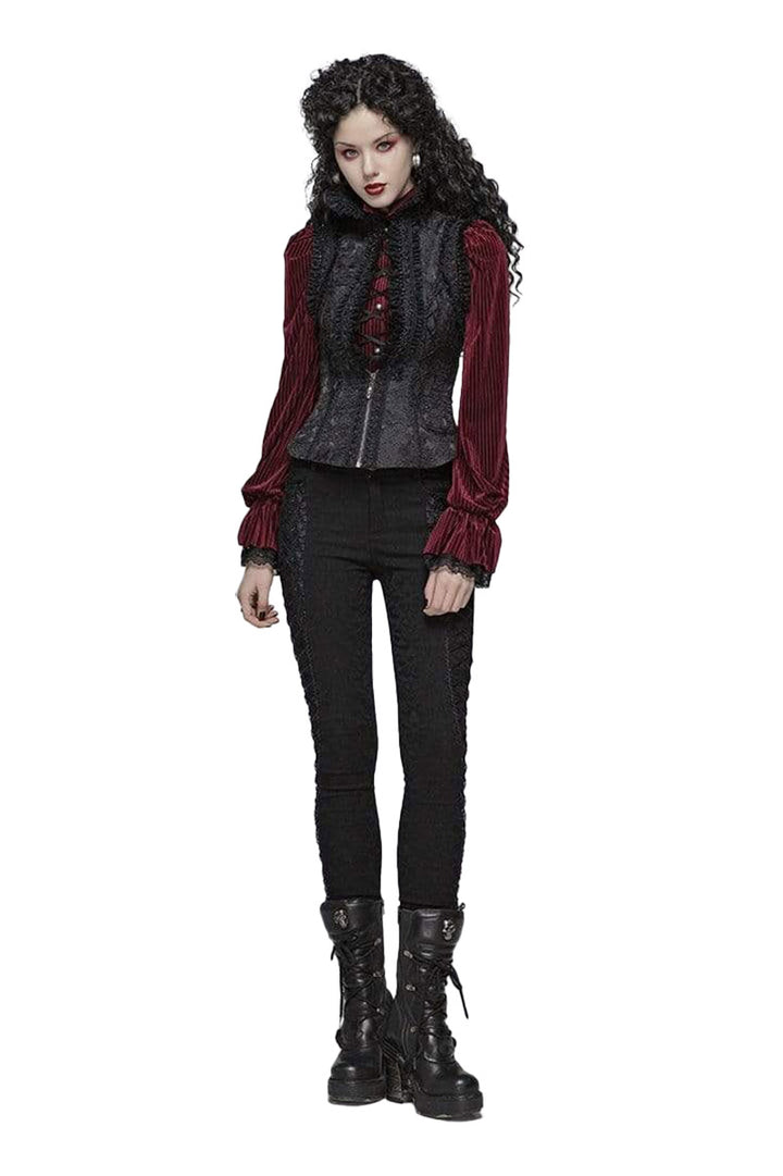 Woman wearing a dark outfit with red accents on a white background