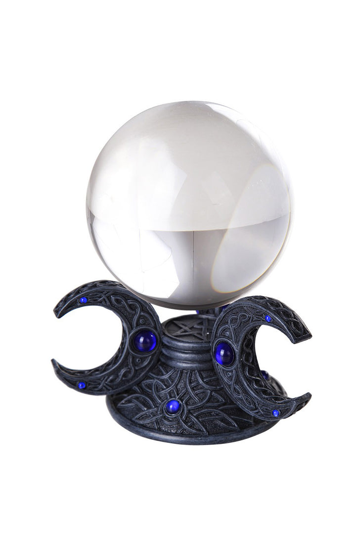 Crystal ball on a black crescent moon stand with blue gemstones against a white background