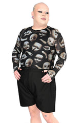 Model wearing a long sleeve black top with creepy dolls