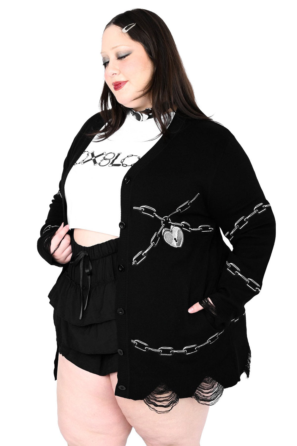 Person wearing a black jacket with chain details on a white background