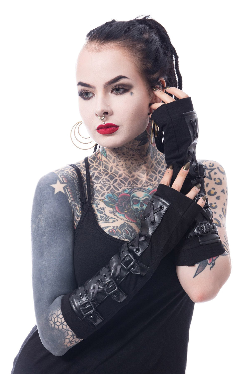 Person with tattoos wearing gothic vegan leather black arm warmers on a white background