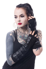 Person with tattoos wearing gothic vegan leather black arm warmers on a white background