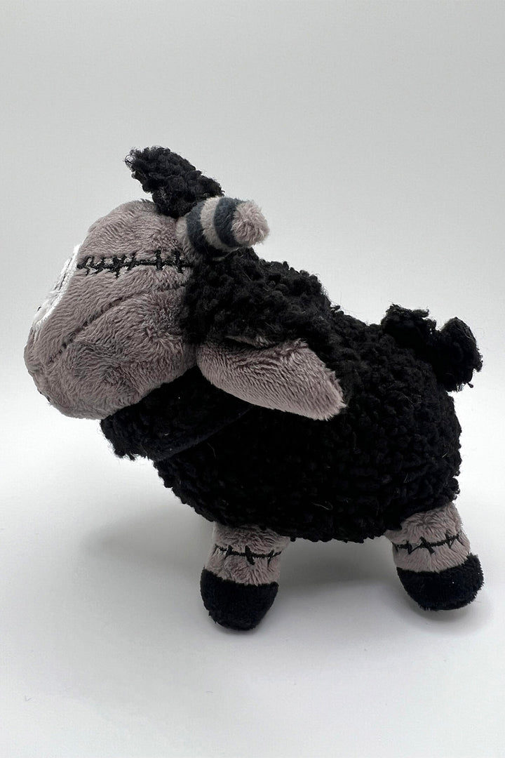stitched monster sheep plush toy with striped horns and an embroidered spiral eyeball 
