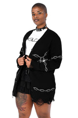 Person wearing a black outfit with chain designs on a white background
