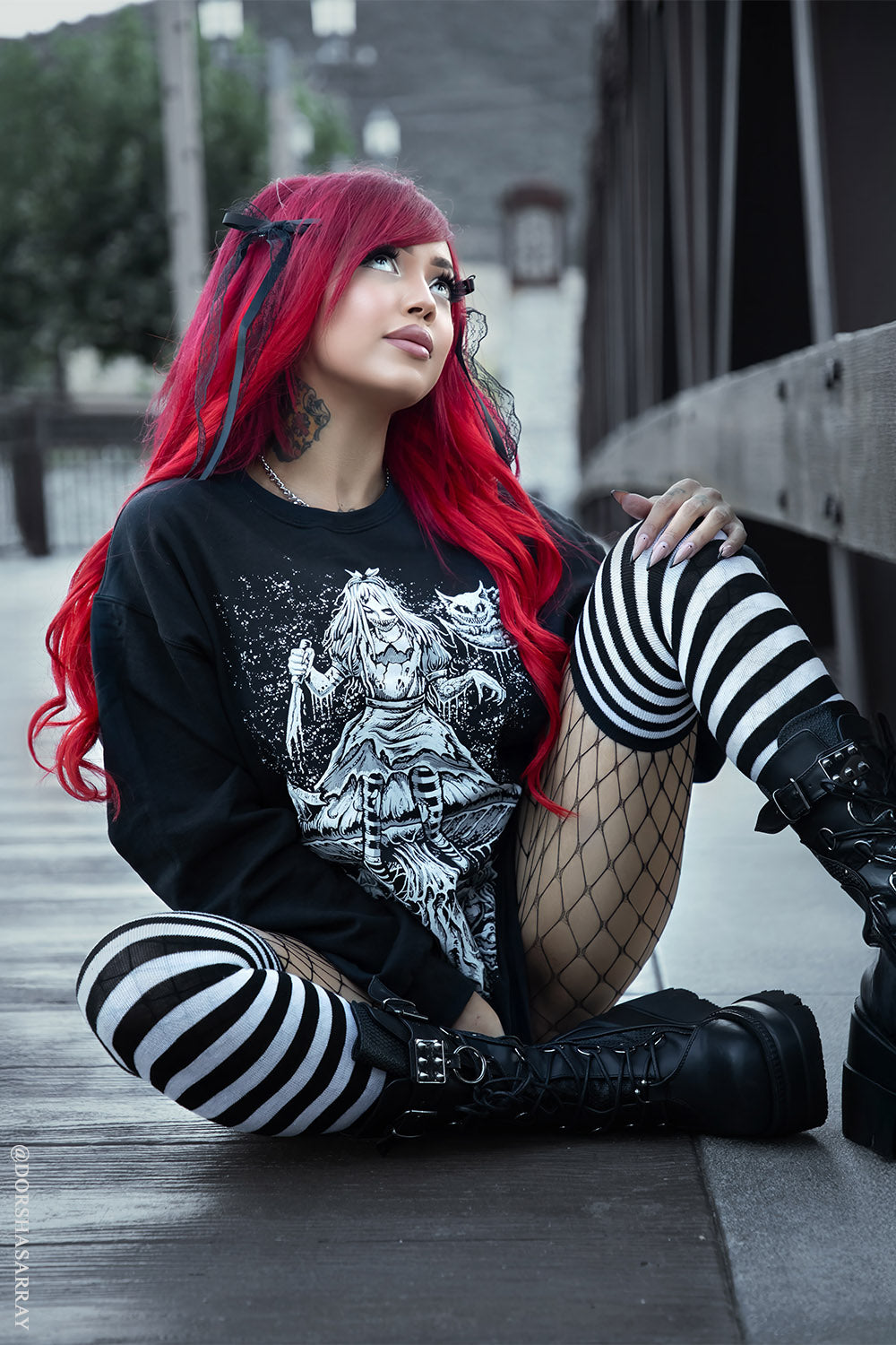 gothic woman with red hair wearing a creepy alice in wonderland sweater