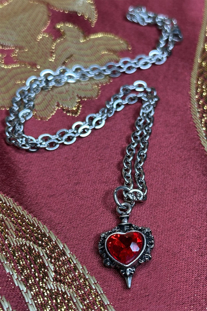 long chain necklace with dagger piercing heart pendant