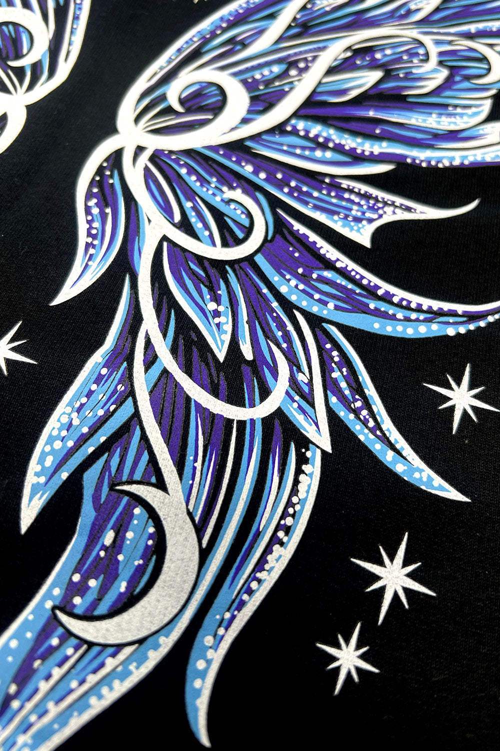 blue, purple, and white moth wings printed on the back of a sweater
