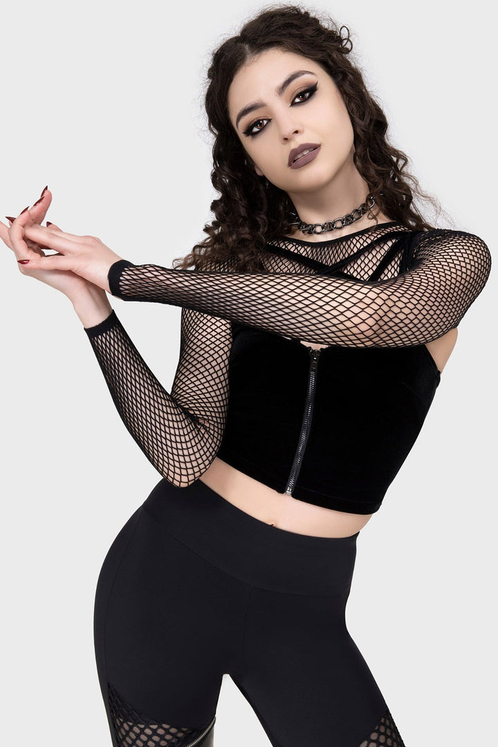 Woman wearing a black outfit with fishnet sleeve shrug bolero on a white background