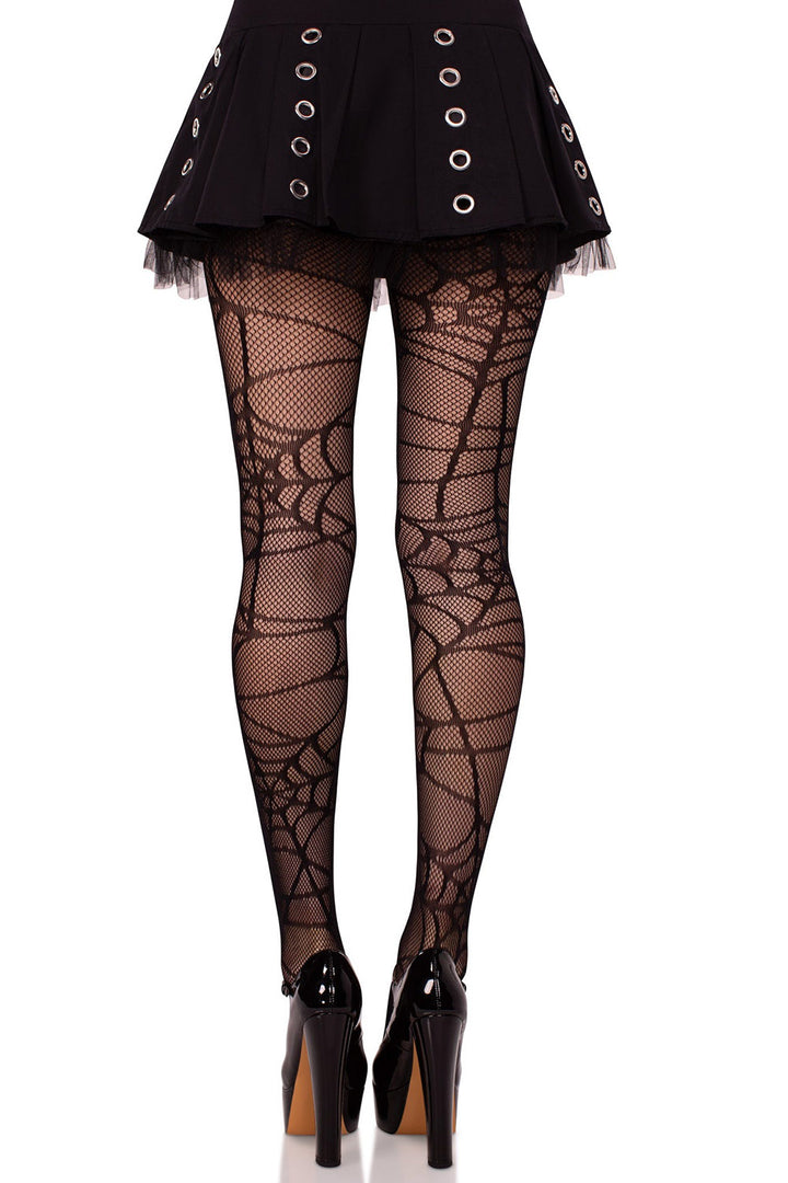 Black fishnet tights worn with a black outfit on a white background